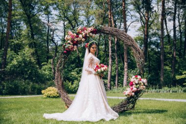 Bir gelin beyaz elbiseli güzel düğün buket tutuyor.