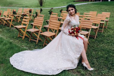 Bir gelin beyaz elbiseli güzel düğün buket tutuyor.