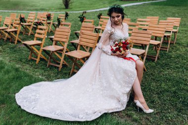 Bir gelin beyaz elbiseli güzel düğün buket tutuyor.