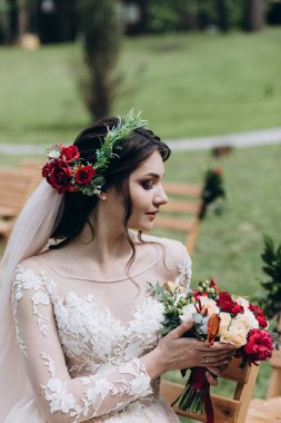 Bir gelin beyaz elbiseli güzel düğün buket tutuyor.