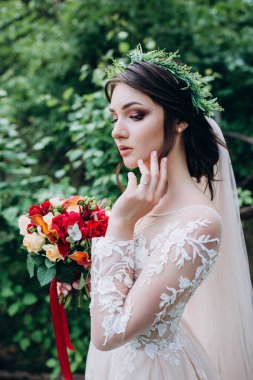 Bir gelin beyaz elbiseli güzel düğün buket tutuyor.