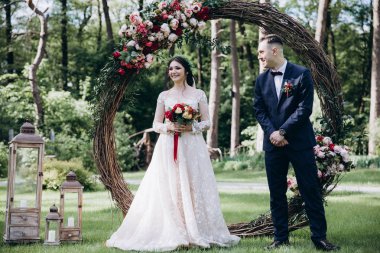 Gelin ve damat çiçek arch yakınındaki düğün.