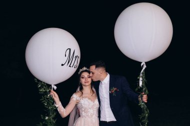 Yeni evliler beyaz topları ile gece yürüyüşü.