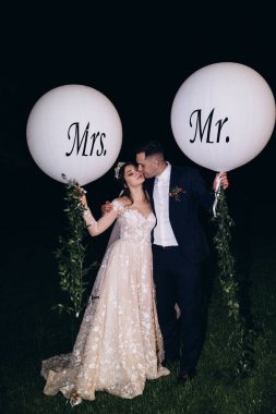 Yeni evliler beyaz topları ile gece yürüyüşü.