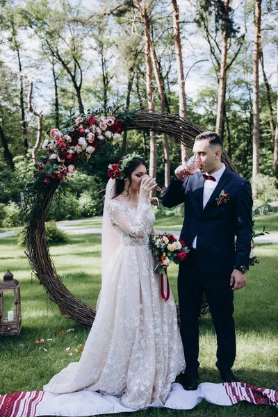 Wedding of the bride and groom near the flower arch.