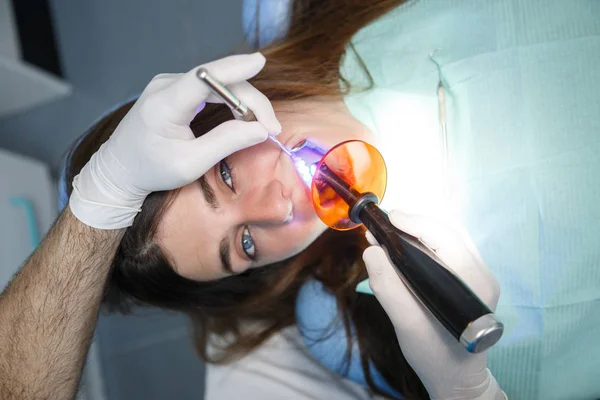 歯医者の歯の充填をして若い女性の手袋での手のビューのトリミング — ストック写真