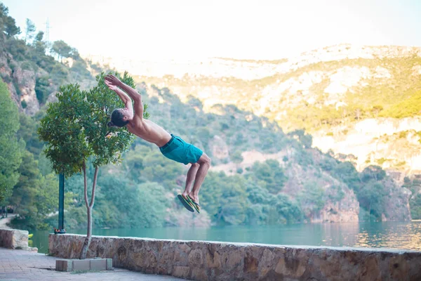 Ung Man Gör Långsida Eller Kullerbytta Samtidigt Öva Parkour Sjö — Stockfoto