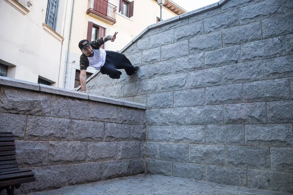 Genç adam sokakta inanılmaz bir parkour hile yaparak.