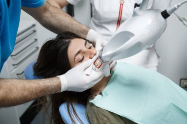 Genç kadın bir diş tedavisi, diş hekimi beyazlatma almak. 