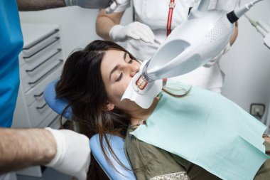 Genç kadın bir diş tedavisi, diş hekimi beyazlatma almak. 