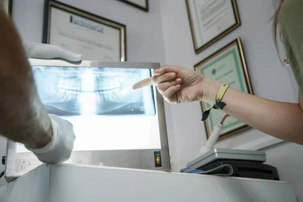 Mujer Joven Mirando Radiografía Boca Mientras Dentista Explica Clínica Dental —  Fotos de Stock