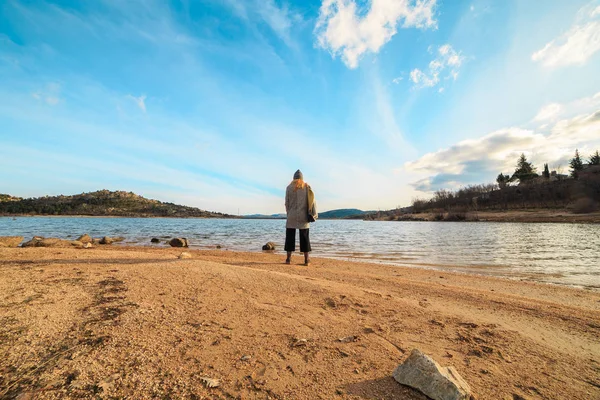 Genç kadın doğru bir göl günbatımı güneşli bir günde mavi gökyüzü ile seyir 