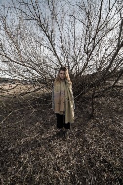 Korkunç bir estetik üreten bir çok dallı ağaç karanlık gölge altında genç kadın