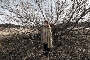 Korkunç bir estetik üreten bir çok dallı ağaç karanlık gölge altında genç kadın