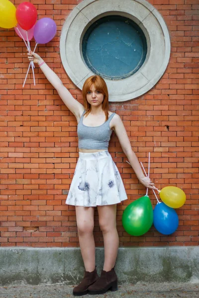 Jonge Vrouw Met Kleurrijke Ballonnen Een Bakstenen Muur Achtergrond — Stockfoto