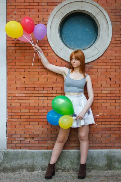 Jonge Vrouw Met Kleurrijke Ballonnen Een Bakstenen Muur Achtergrond — Stockfoto