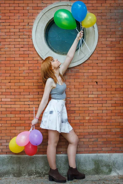 Jonge Vrouw Met Kleurrijke Ballonnen Een Bakstenen Muur Achtergrond — Stockfoto