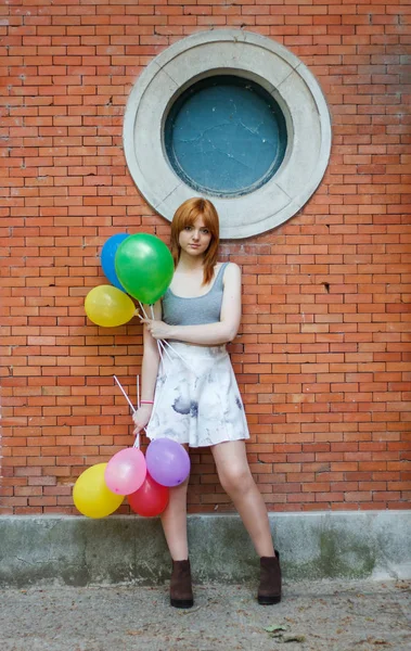 Jonge Vrouw Met Kleurrijke Ballonnen Een Bakstenen Muur Achtergrond — Stockfoto