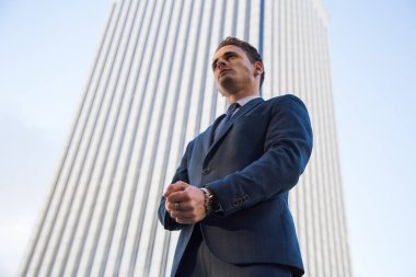 Güvenle modern ofis gökdelen arka plan üzerinde poz zarif şık adam görünümünü aşağıdan uygun 