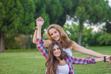 Zevk ve güneşli bir günde parkta gülen genç kadın.