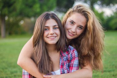 Zevk ve güneşli bir günde parkta gülen genç kadın.