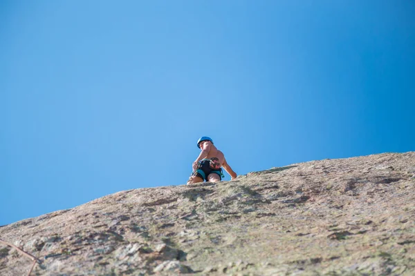 クライミングウォール山驚くほど晴れた日に上半身裸の男性登山家のショットの下から — ストック写真