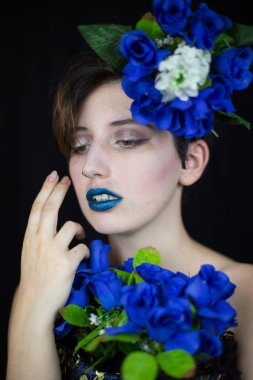 Şehvetli genç kadın yüzüne dokunmaktan ve uzakta ile mavi çiçek kompozisyon arıyorum  