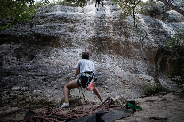 下ハーネスで匿名の人の山を見上げてチェック パートナーと登山の崖 — ストック写真