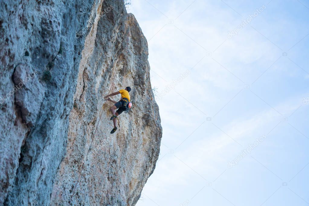 View of man without helmet hanging on a rope while rappelling and shows flying pirouettes in the air 