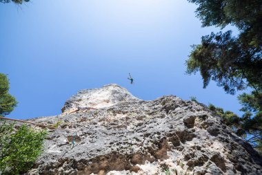 Dağcı atış aşağıdan iken diğer Tırmanma dağ mavi gökyüzü altında üstünden atlama ip ile güvenli
