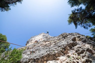 Dağcı atış aşağıdan iken diğer Tırmanma dağ mavi gökyüzü altında üstünden atlama ip ile güvenli