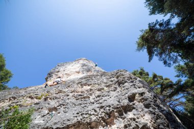 Dağcı atış aşağıdan iken diğer Tırmanma dağ mavi gökyüzü altında üstünden atlama ip ile güvenli