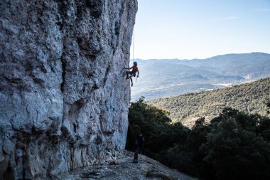 Genç climber erkeği gölge güzel bir manzara içinde büyük bir duvar tırmanışı 