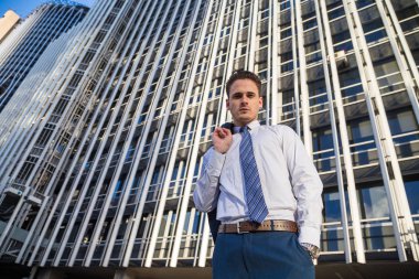 Şık takım elbise ceketi modern ofis gökdelen arka plan üzerinde tutan işadamı.