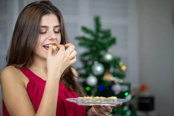 Plaka lezzetli badem ezmesi tatlılar tutarak ve Noel'de yeme kadın 