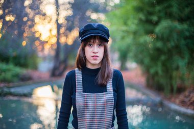 Gün batımında paradisiacal bir parkta poz şık giysileri ile genç kadın