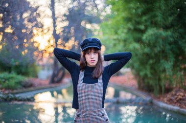 Gün batımında paradisiacal bir parkta poz şık giysileri ile genç kadın