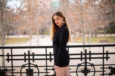 Bir çit oturan bir parkta poz güzel model kadın