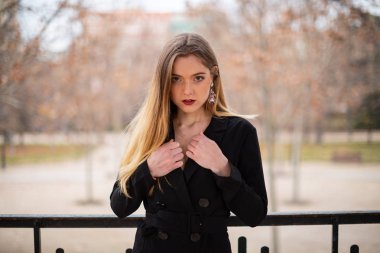 Bir çit oturan bir parkta poz güzel model kadın