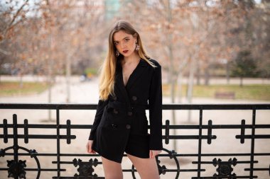 Bir çit oturan bir parkta poz güzel model kadın