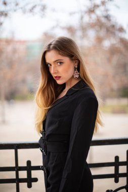 Bir çit oturan bir parkta poz güzel model kadın