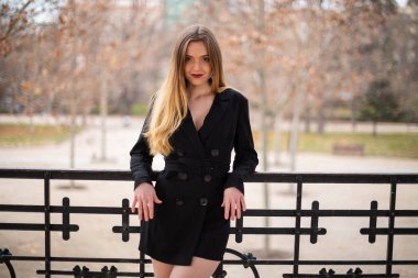 Bir çit oturan bir parkta poz güzel model kadın