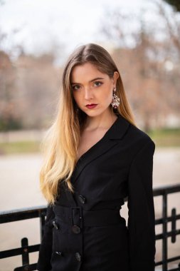 Bir çit oturan bir parkta poz güzel model kadın