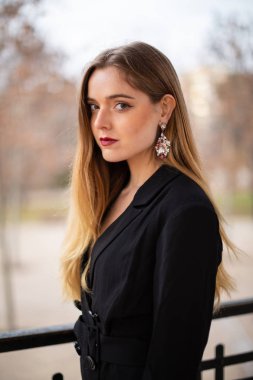 Bir çit oturan bir parkta poz güzel model kadın