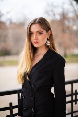 Bir çit oturan bir parkta poz güzel model kadın