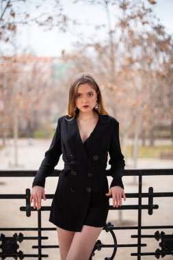 Bir çit oturan bir parkta poz güzel model kadın