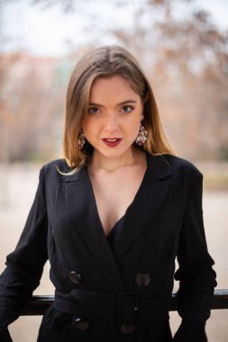 Bir çit oturan bir parkta poz güzel model kadın