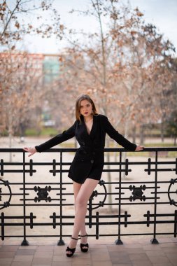 Bir çit oturan bir parkta poz güzel model kadın