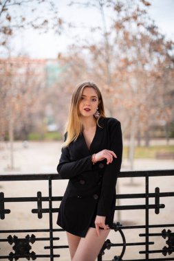 Bir çit oturan bir parkta poz güzel model kadın