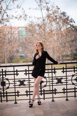 Bir çit oturan bir parkta poz güzel model kadın